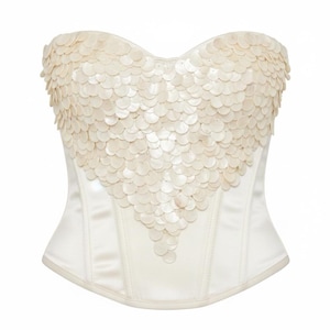 May include: Ivory-colored corset with a heart-shaped sequin design on the bodice. The corset is made of a satin-like material and features a structured silhouette. The sequins are circular and arranged in overlapping rows.