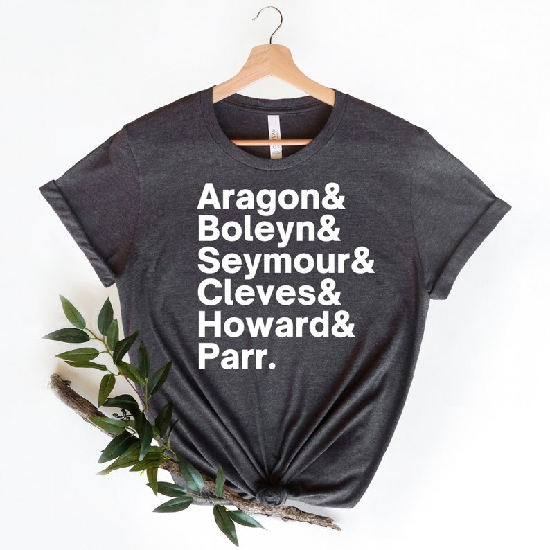 May include: A dark grey t-shirt with white text that reads "Aragon & Boleyn & Seymour & Cleves & Howard & Parr."