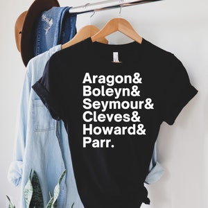 May include: Black t-shirt with white text that reads "Aragon & Boleyn & Seymour & Cleves & Howard & Parr."