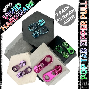 May include: A selection of vibrant nylon zipper pulls in teal, green, purple, and pink. The image features the text "Vivid Hardware" and "Pop Tab Zipper Pull". The zipper pulls are presented on geometric concrete blocks.