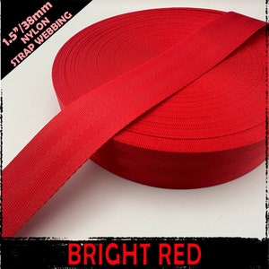 Puede incluir: Un rollo de cincha de nailon rojo brillante, de 38 mm de ancho. El texto "1.5"/38mm NYLON STRAP WEBBING" está en la esquina superior izquierda, y "BRIGHT RED" en la parte inferior. La cincha está enrollada apretada, con una superficie texturizada visible.