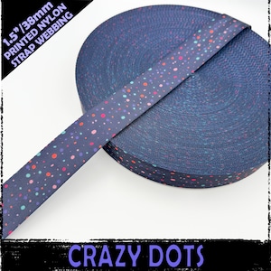 May include: 1.5 inch / 38mm wide navy blue nylon webbing with a colourful polka dot print. The webbing is rolled up and the print is visible on both the rolled and unrolled portions. "CRAZY DOTS" is printed in purple letters on the bottom of the image.