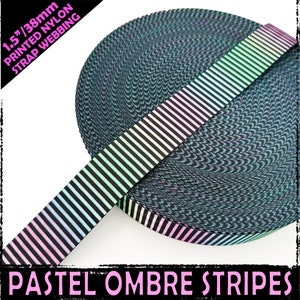 Puede incluir: Cinta de nylon de 38 mm de ancho con rayas de degradado pastel. Las rayas son negras y un degradado de colores pastel. La cinta está enrollada y las rayas son visibles en el lateral del rollo.
