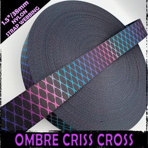 Puede incluir: Un rollo de cinta de nylon negra de 3,8 cm de ancho con un patrón de cruz en tonos degradados de morado, rosa, azul y turquesa. El texto "OMBRE CRISS CROSS" está impreso en rosa debajo del rollo.