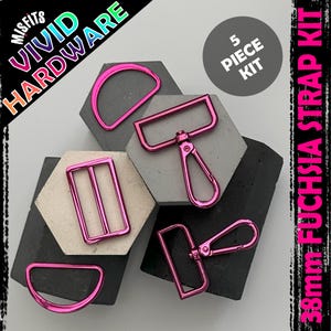 Puede incluir: Un kit de correas fucsia de 5 piezas con varios herrajes, incluyendo anillas en D, hebillas rectangulares y mosquetones. El kit se muestra sobre formas geométricas. El texto dice "38mm Fuchsia Strap Kit". La marca "Vivid Hardware" también es visible.