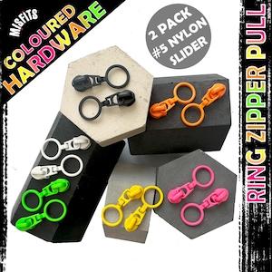 以下が含まれることがあります： 黒、白、緑、オレンジ、黄色、ピンクなど、さまざまな色のカラフルなリングジッパープル。画像には「MISFITS COLOURED HARDWARE」と「2 PACK #5 NYLON SLIDER」というテキストが含まれています。