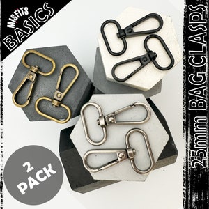Puede incluir: Dos paquetes de cierres de bolsa de 25 mm en plata y latón. Los cierres se muestran sobre un fondo gris y blanco. El texto "2 PACK" es visible en la esquina inferior izquierda de la imagen.