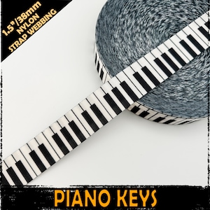 May include: A roll of 38mm nylon strap webbing with a piano key pattern. The webbing displays a white base with black piano keys. The text "PIANO KEYS" is in orange at the bottom of the image.
