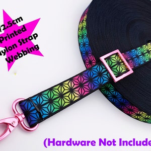 May include: Black nylon strap webbing with a vibrant geometric pattern in rainbow colours. The strap is 2.5cm wide and features a pink metal clasp and buckle. Text on the image reads "1"/2.5cm Printed Nylon Strap Webbing" and "(Hardware Not Included)".