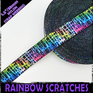 Puede incluir: Un rollo de cinta de nylon negra de 38 mm de ancho con un estampado de arcoíris "Rainbow Scratches".