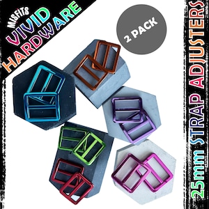 May include: Two pack of 25mm strap adjusters in a variety of colours, including blue, green, red, orange, purple, and pink. The adjusters are made of metal and have a shiny finish. The image also includes the text "VIVID HARDWARE" and "2 PACK".