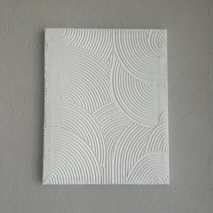 Könnte beinhalten: Weiße strukturierte Wandkunst mit einem erhabenen Muster aus konzentrischen Kreisen.