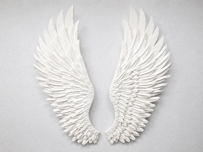 May include: A pair of white, textured angel wings, displayed against a light gray background. The wings are detailed with individual feathers, creating a sense of depth and dimension. The artwork is symmetrical and evokes a sense of peace.