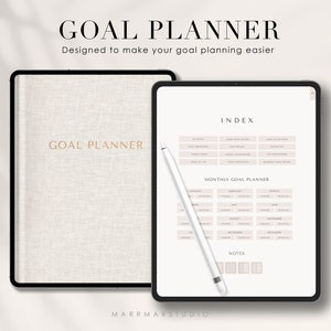 May include: A digital goal planner on a tablet screen with a white stylus. The planner has a monthly goal planner section with a calendar for each month of the year. The planner also has an index section with categories for goal setting.