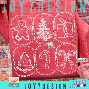 May include: Red sweatshirt with white Christmas-themed graphics. The design includes a gingerbread man, Christmas tree, gift, candy cane, and bow, each within a scalloped frame. The text "JOY7DESIGN" is visible.