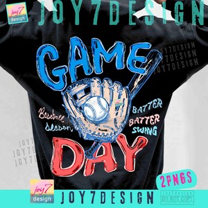 May include: Black t-shirt with a baseball-themed graphic. The design features the words "GAME DAY" in red and blue, a baseball, glove, and bat. Additional text includes "Baseball Season", "Batter, Batter, Swing".