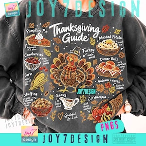 May include: A charcoal gray sweatshirt featuring a Thanksgiving Guide graphic with a central turkey wearing a hat and scarf, surrounded by illustrations of pumpkin pie, mashed potatoes, cranberries, dinner rolls, corn, stuffing, gravy, and a cornucopia.
