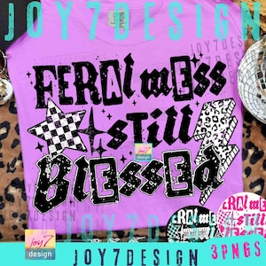 May include: A lilac-colored t-shirt with the words "FERAL mess Still BLESSED" in a distressed black font. The design includes a checkered star, a lightning bolt with a leopard print, and small star accents. The brand name "JOY7 DESIGN" is also visible.