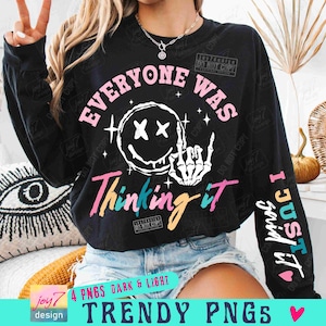 May include: Black long-sleeve shirt with a graphic design featuring a smiley face with a middle finger, stars, and the text "Everyone Was Thinking It I Just Said It".