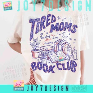 May include: Cream-coloured t-shirt featuring a blue and purple graphic that says "Tired Moms Book Club." The design includes illustrations of books, plants, candles, and stars. The text "Running on coffee, chaos & chapters" is also included.