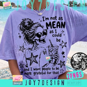 May include: A light purple t-shirt featuring a black graphic of a skeleton wearing sunglasses and holding a drink. The text reads "I'm not as MEAN as I could be and I want people to be more grateful for that."