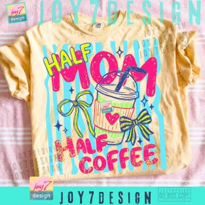 May include: A light yellow t-shirt with a colorful graphic design. The design features the words "HALF MOM HALF COFFEE" in bright pink and yellow, along with a cartoon coffee cup and bows. The shirt has a crew neck and short sleeves.