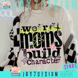 May include: A white t-shirt with the text "weird moms build character" in black, yellow, and pink. The shirt has a graphic design with stars and a heart. The background includes a black and white checkered sweater.