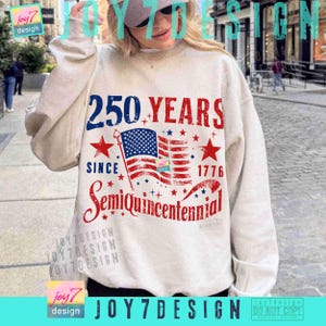 May include: Cream-colored sweatshirt with a patriotic design celebrating the 250th anniversary since 1776. The graphic includes the American flag, stars, and the words "250 YEARS" and "SemiQuincentennial."