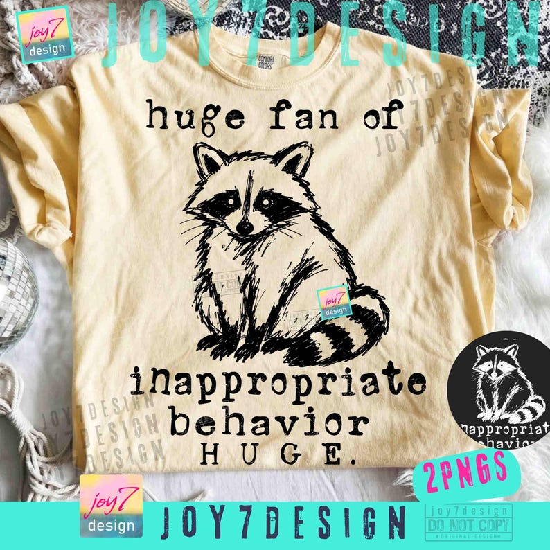 May include: A light yellow t-shirt featuring a black and white raccoon illustration. The text "huge fan of inappropriate behavior HUGE" is printed below the raccoon. A small circular graphic of the raccoon is on the right.
