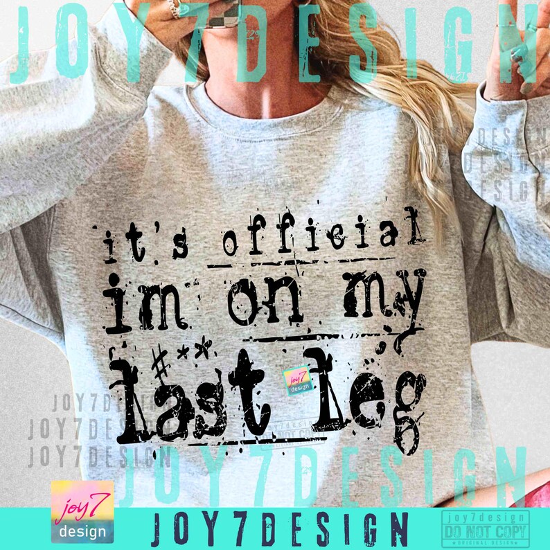 May include: A light gray sweatshirt with the text "it's official im on my last leg" in black. The sweatshirt has a crew neck and long sleeves. The design is a distressed, vintage style.