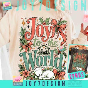 May include: A cream-colored sweatshirt featuring a graphic print with the text Joy to the World. The design includes a nativity scene, a sleeping lamb, holly leaves, berries, and red ribbons. The lettering is in red and green with a distressed texture.