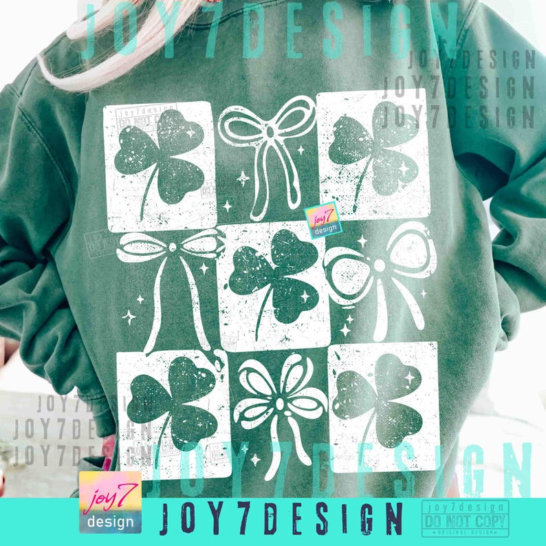 Puede incluir: Sudadera verde con un dise&ntilde;o de cuadr&iacute;cula de tr&eacute;boles y lazos blancos, con un aspecto vintage y desgastado. El texto "joy7 design" es visible en la parte inferior. Una prenda de vestir con tem&aacute;tica del D&iacute;a de San Patricio.
