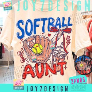Op de afbeelding: Crèmekleurig T-shirt met een softbalafbeelding. Het ontwerp bevat het woord "SOFTBALL" in blauw, een honkbalhandschoen, een gele softbal en het woord "AUNT" in rood. Een drankje met een rietje en een strik zijn ook inbegrepen.