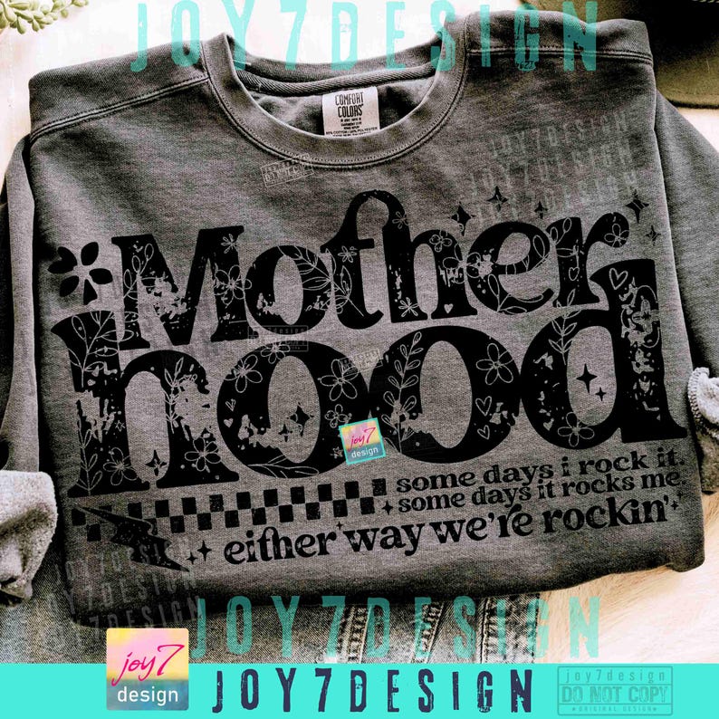 Peut inclure: Un sweat-shirt gris avec le mot "Motherhood" en grandes lettres noires d&eacute;cor&eacute;es de motifs floraux. Le texte "some days I rock it, some days it rocks me, either way we're rockin'" est imprim&eacute; en dessous. Le sweat-shirt a une &eacute;tiquette Comfort Colors.