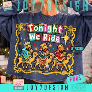Könnte beinhalten: Ein dunkelblaues Sweatshirt mit Rundhalsausschnitt und einer Grafik von drei Königen auf Kamelen mit dem Text Tonight We Ride. Das Design enthält bunte Blockbuchstaben, goldene Sterne und einen gelben Zierrahmen auf einem Stoff im Vintage-Look.