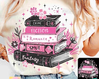 May include: Cream-colored t-shirt featuring a stack of books with the words "Crime", "Fiction", "Romance", "Smut", and "Fantasy" in black and pink. The design includes floral and star accents. The text "JOY7DESIGN" is at the bottom.