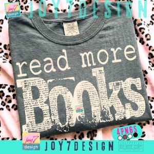 以下が含まれることがあります： チャコールグレーのクルーネックTシャツ。シンプルな白いフォントで「read more」と書かれ、その下に大きく太い白いフォントで「BOOKS」とプリントされています。この「BOOKS」の文字の中には、白黒の新聞記事のような細かい模様がデザインされています。