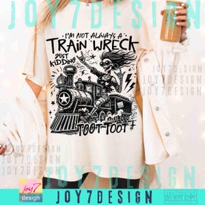 May include: Cream-colored t-shirt with a black and white graphic of a train and a skeleton. The text on the shirt reads "I'M NOT ALWAYS A TRAIN WRECK JUST KIDDING TOOT TOOT #". The design includes a star and lightning bolts.