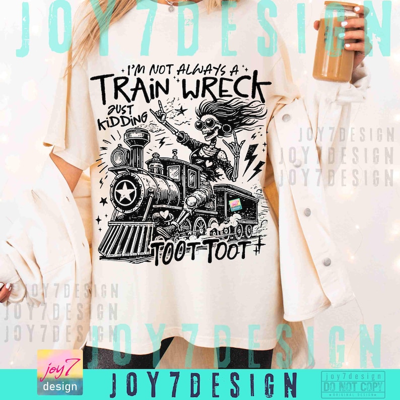 May include: Cream-colored t-shirt with a black and white graphic of a train and a skeleton. The text on the shirt reads "I'M NOT ALWAYS A TRAIN WRECK JUST KIDDING TOOT TOOT #". The design includes a star and lightning bolts.