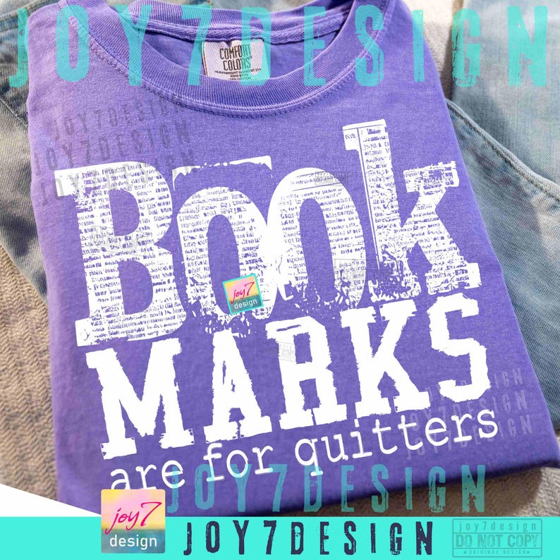 May include: A purple t-shirt with the words "BOOK MARKS are for quitters" in white block letters. The word "BOOK" is filled with a newspaper-like pattern. The shirt has a Comfort Colors tag.