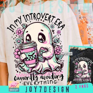May include: White t-shirt featuring a cartoon ghost holding a coffee cup and a smartphone. The ghost is surrounded by flowers and the text reads "IN MY INTROVERT ERA" and "currently avoiding EVERYTHING."