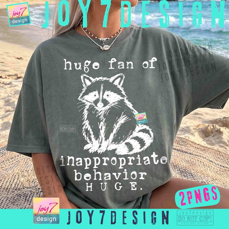 May include: A sage green t-shirt featuring a white illustration of a raccoon and the text "huge fan of inappropriate behavior HUGE." The design includes the brand name "joy7 design."