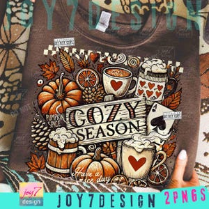 May include: Brown sweatshirt with a fall-themed graphic. The design includes pumpkins, coffee mugs with hearts, leaves, and the text "COZY SEASON" and "Have a nice day".