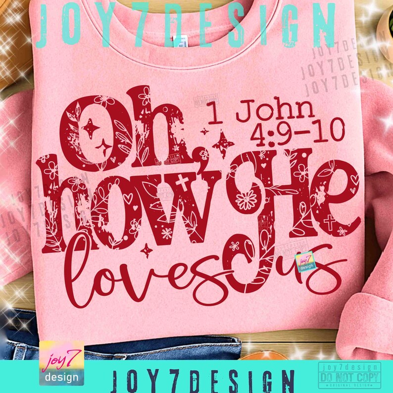 May include: A light pink sweatshirt with the text "Oh how He loves us" in a decorative red font. The text also includes the Bible verse "1 John 4:9-10". The design features floral and star accents.