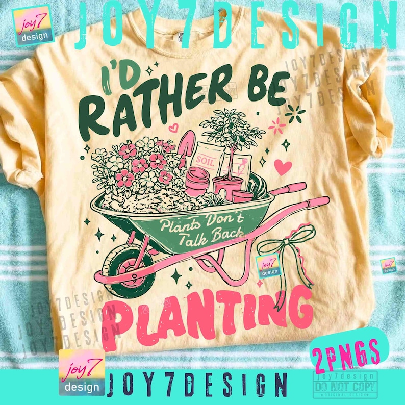 May include: A light yellow t-shirt with a gardening theme. The shirt features a graphic of a wheelbarrow filled with plants and the text "I'd Rather Be Planting". The design includes the text "Plants Don't Talk Back".
