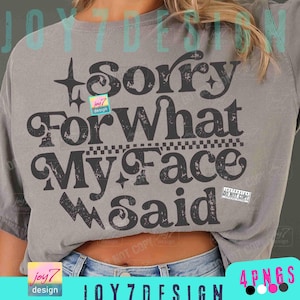 Può includere: T-shirt grigio con la scritta "Sorry For What My Face Said" in un carattere audace e invecchiato. Il design include stelle e diamanti. La maglietta ha una vestibilità ampia.