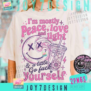 Puede incluir: Camiseta color crema con un diseño gráfico en rosa y morado. El diseño incluye el texto "I'm mostly Peace, love and light & a little Go fuck Yourself" con una carita sonriente, una bebida y rayos.
