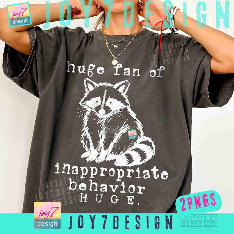May include: Dark gray t-shirt featuring a white illustration of a raccoon and the text "huge fan of inappropriate behavior HUGE." The shirt has a vintage, worn look.
