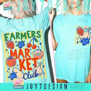 May include: Light blue t-shirts with a colorful "Farmers Market Club" graphic. The design includes illustrations of fruits and vegetables like strawberries, blueberries, cherries, tomatoes, potatoes, and an onion. The shirts have a vintage, slightly faded look.