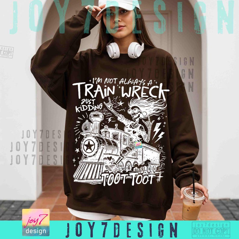 May include: Brown sweatshirt with a white graphic of a skeleton riding a train, with the text "I'M NOT ALWAYS A TRAIN WRECK JUST KIDDING TOOT TOOT #". The sweatshirt has a crew neck and long sleeves.